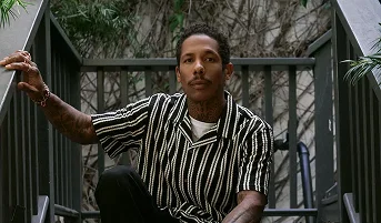 Close-up of man in striped shirt sitting on stairs outdoors